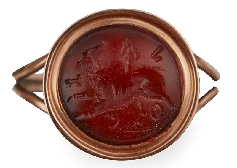 AN 18TH CENTURY MOUNTED 5TH/6TH CENTURY SASSANIAN CARNELIAN INTAGLIO RING the convex carnelian intaglio carved with a Chimera amongst various Roman phallic and other symbols in a reeded yellow gold mount with bifurcated shoulders and plain shank  Ring size: R, intaglio diameter: 11.5mm  Provenance: Lots 111 - 119 from a private collection.  Duke of Wellington Collection (1807-1884), The Wellington Gems exhibition, possibly no 9, S.J Phillips, London 1977.  Sold for £3,000